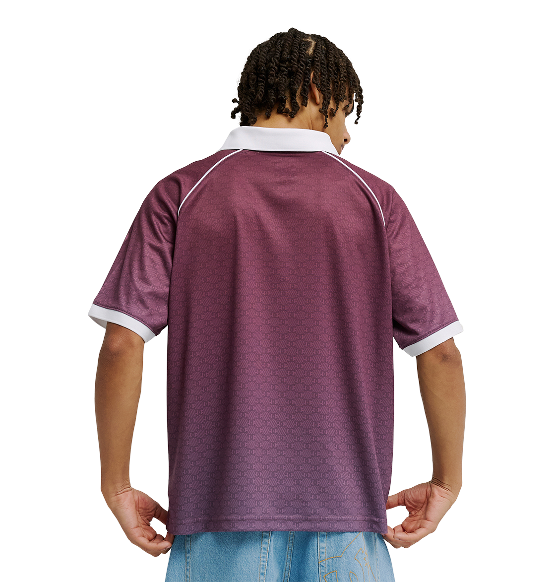 A person with short, curly hair is seen from the back wearing the Men's DC Soccer Top by DC Shoes—featuring a maroon color with white-trimmed collar and sleeves—styled with light blue jeans against a plain white background.