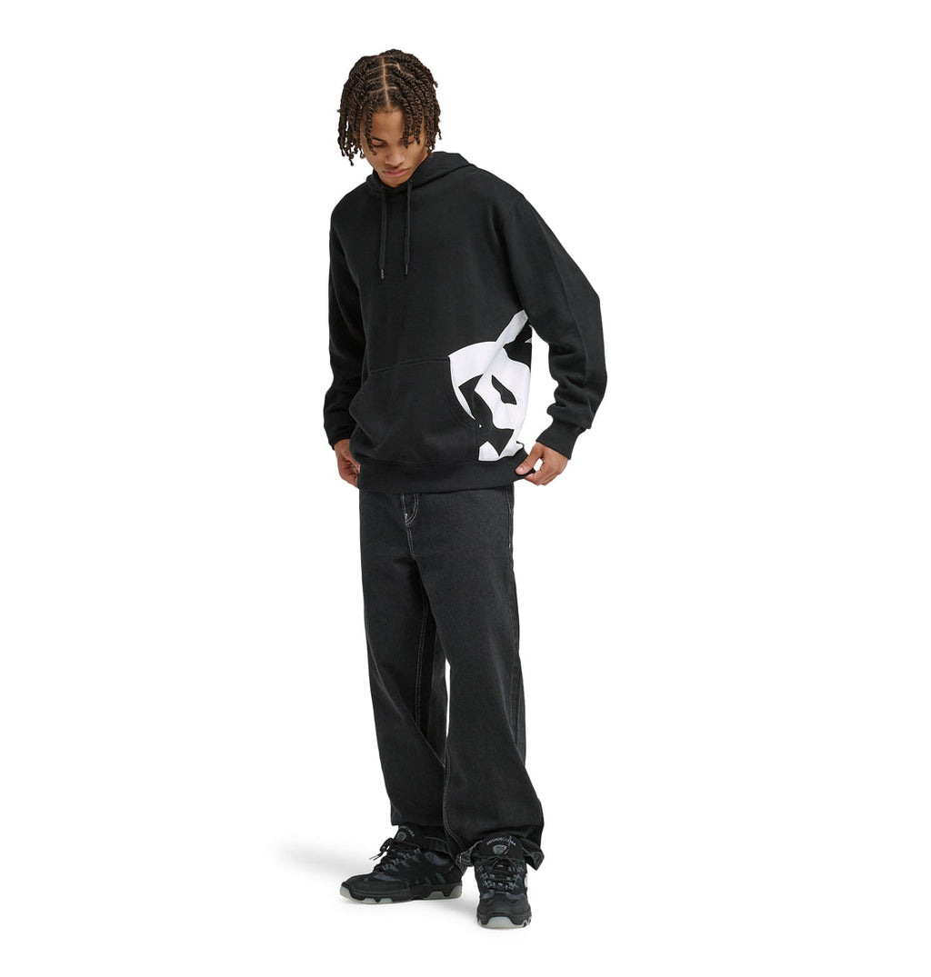 Wearing the Reebok Lanai Ph black hoodie with a bold white graphic, paired with loose black jeans and black sneakers, a person stands looking down, hands in the hoodie pocket, against a plain white backdrop.