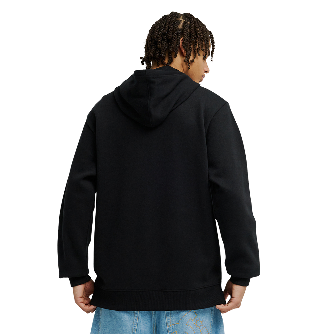 A person with short, curly hair is seen from behind wearing the Men’s DC Strass Star Hoodie by DC Shoes—a black pullover featuring a rhinestone DC star—paired with light blue jeans, standing against a plain white background.
