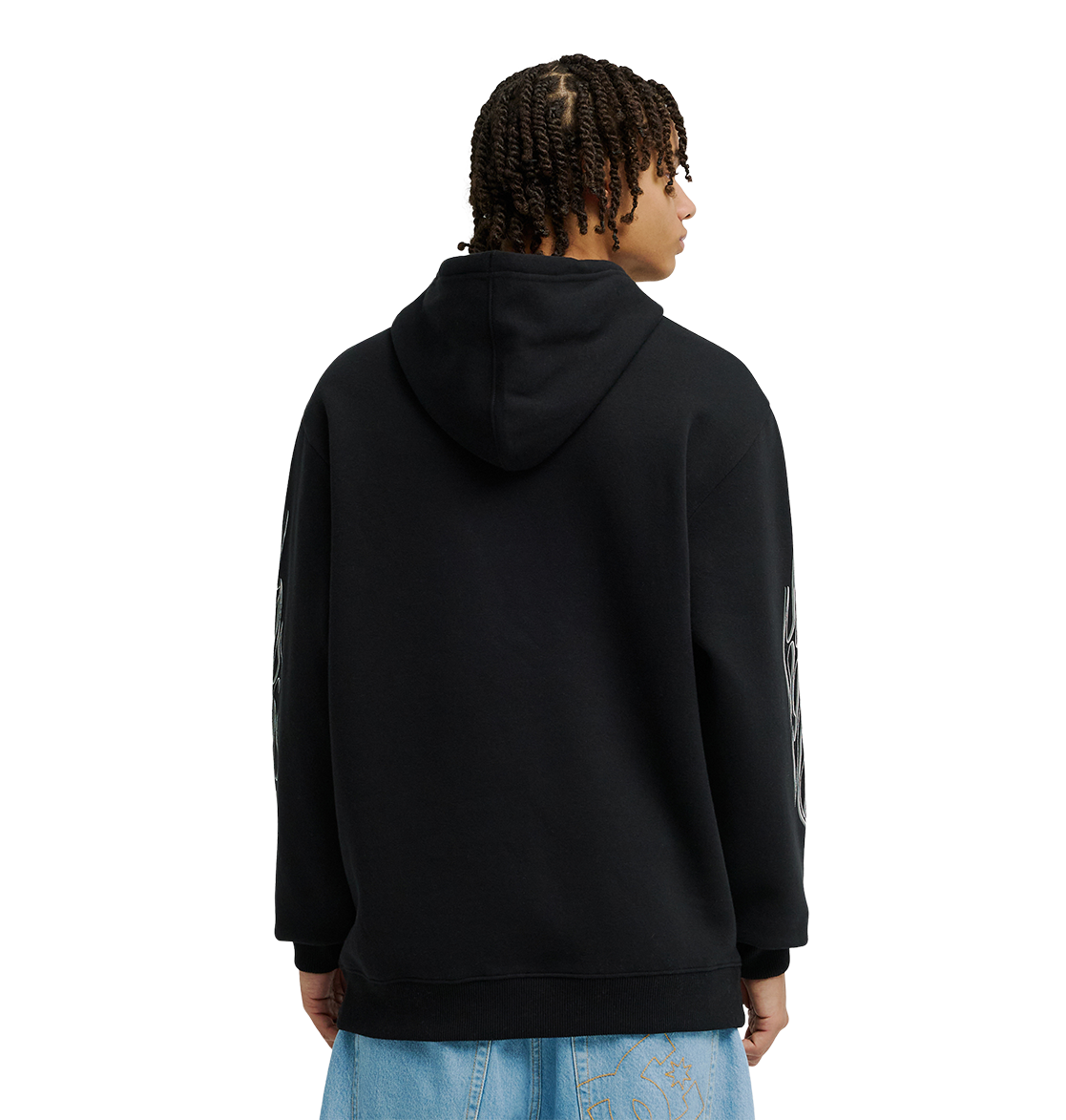 A person with short twists wears the DC Shoes Men's Side Flame Hoodie, a black pullover known for its fleece warmth, along with light blue jeans, facing away from the camera against a plain white background.