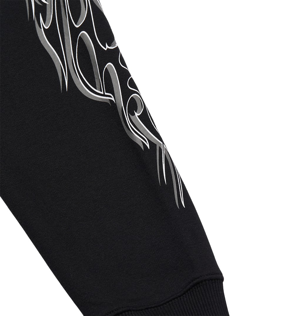 The Men's Side Flame Hoodie by DC Shoes features a black sleeve adorned with a white, abstract flame design near the upper part, evoking the brand's bold graphic style. Finished with a ribbed cuff for added detail and comfort, this hoodie stands out against its plain white background.