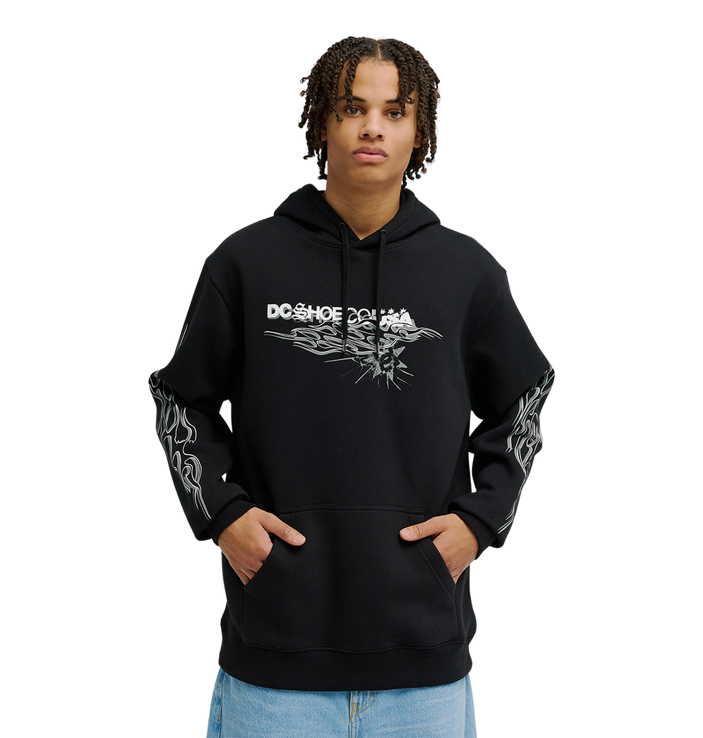 A person wearing the Men's Side Flame Hoodie from DC Shoes—a black pullover featuring bold white DC graphics on the front and sleeves—stands with hands in the spacious front pocket against a simple, light backdrop. The hoodie’s fleece construction delivers cozy warmth and stylish comfort to the overall look.