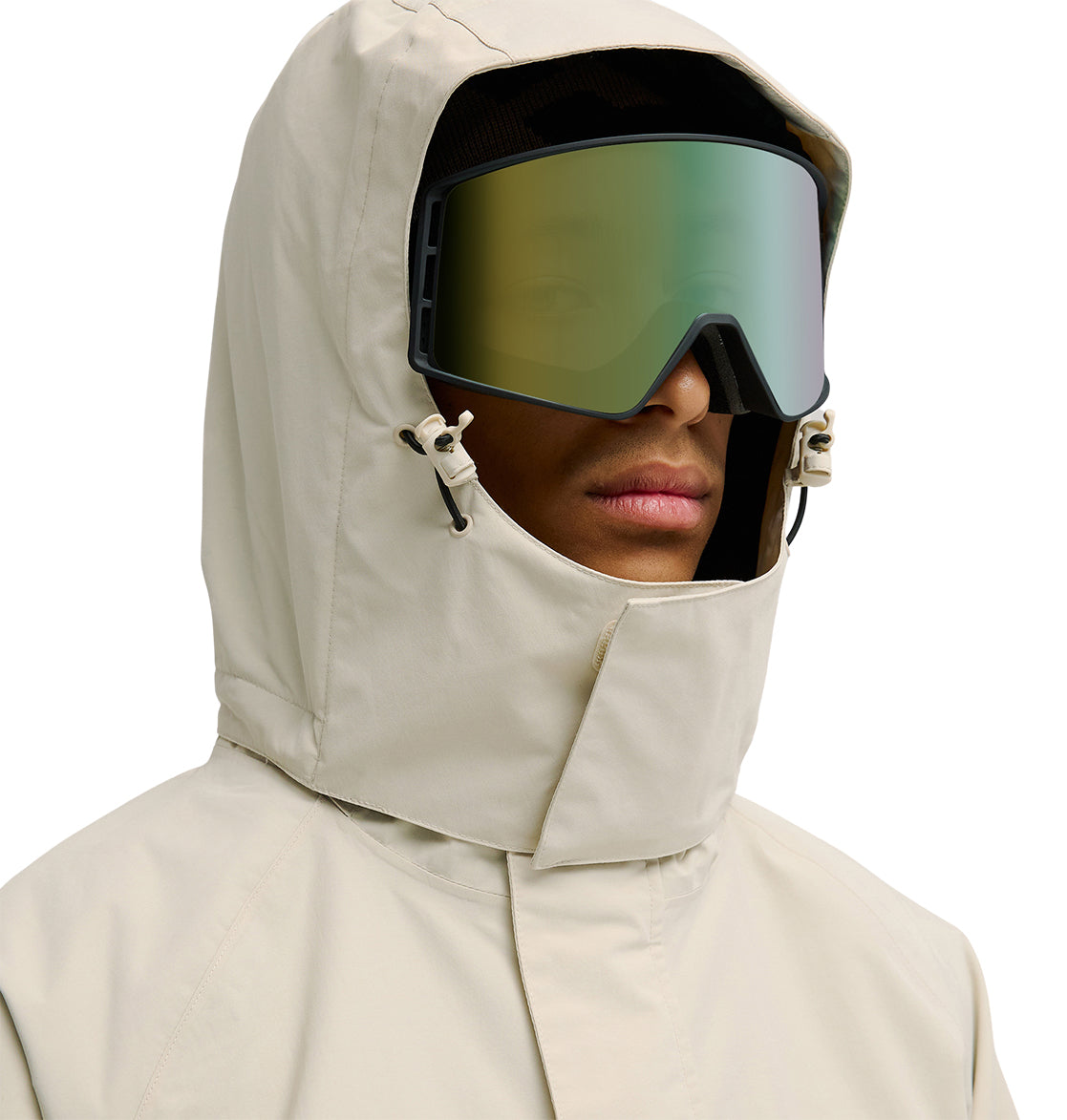 A person faces forward, their face partially covered by the hood of the DC Shoes Mountain Lab Jacket 20K in beige, and wears large reflective ski goggles. The jacket provides breathable protection for superior snow performance. The background is white.