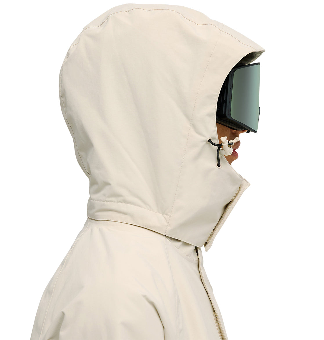 A person in the DC Shoes Mountain Lab Jacket 20K—a beige hooded jacket designed for breathable protection—paired with large ski goggles, shown in profile facing right against a white background.
