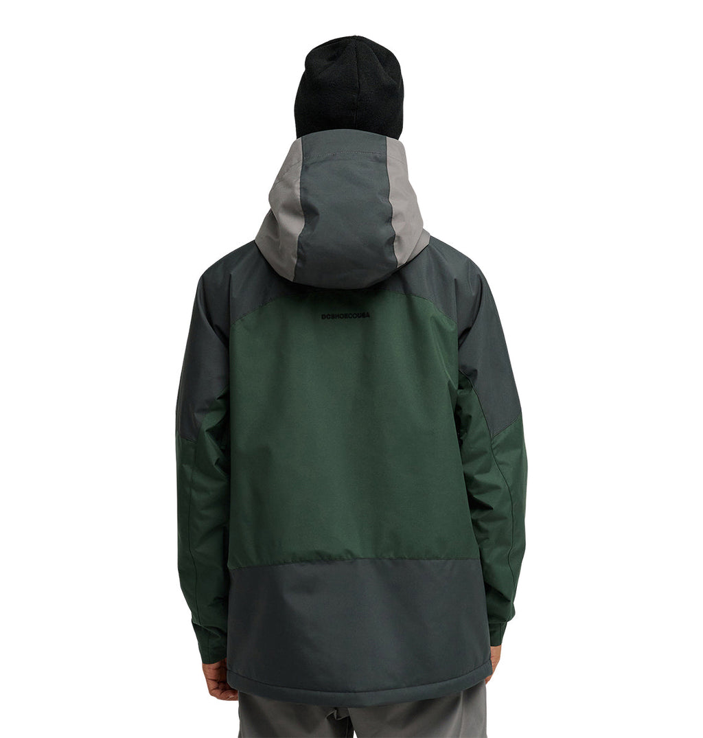 A person wearing the DC Shoes Coldsmoke Jacket 10K—a green and gray snow performance jacket with breathable protection—and a black beanie stands facing away from the camera against a plain white background.