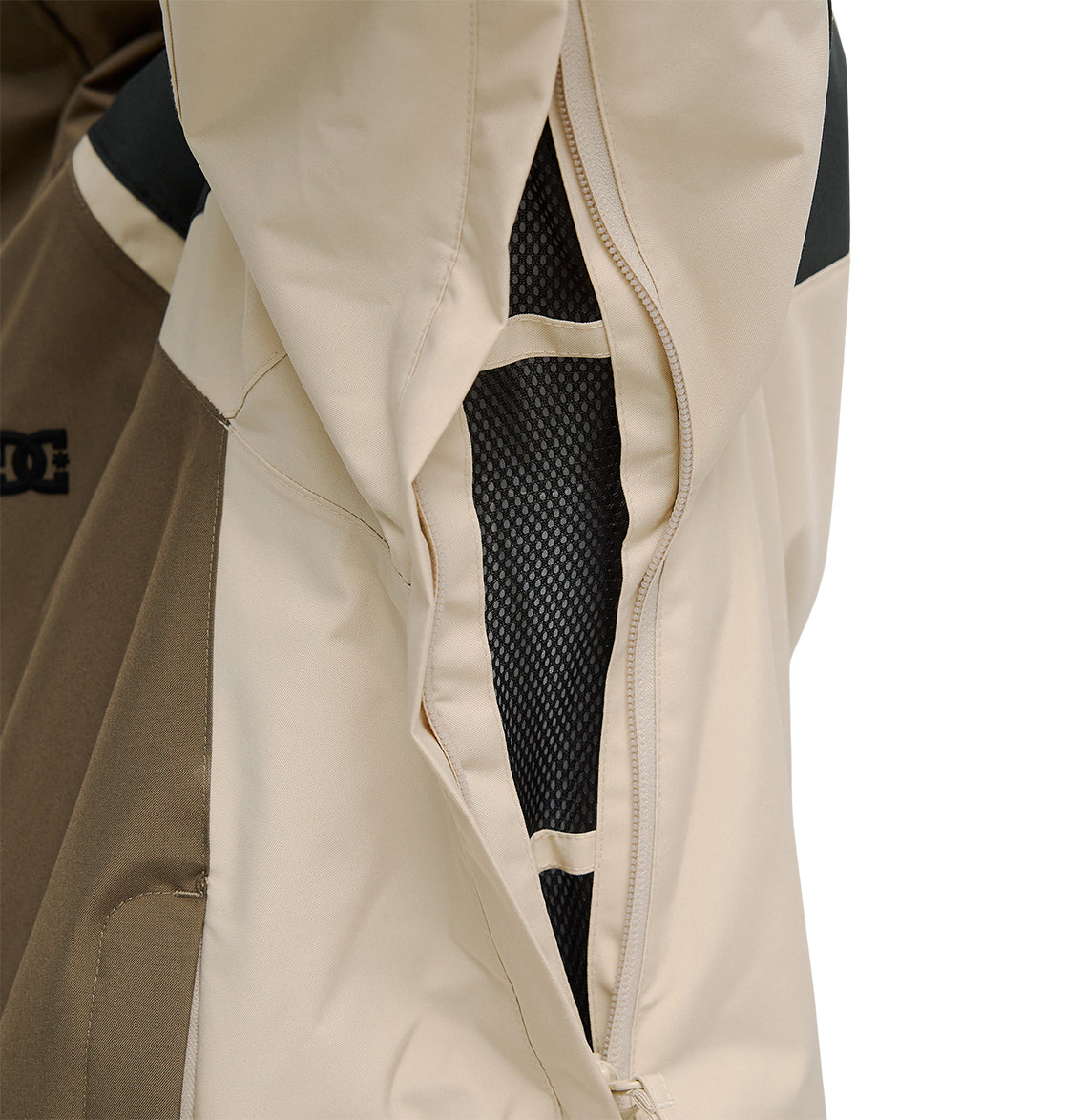 Close-up of the DC Shoes Coldsmoke Jacket 10K in beige and brown, featuring a partially unzipped vent that reveals black mesh lining beneath, delivering breathable protection for optimal comfort in changing conditions.
