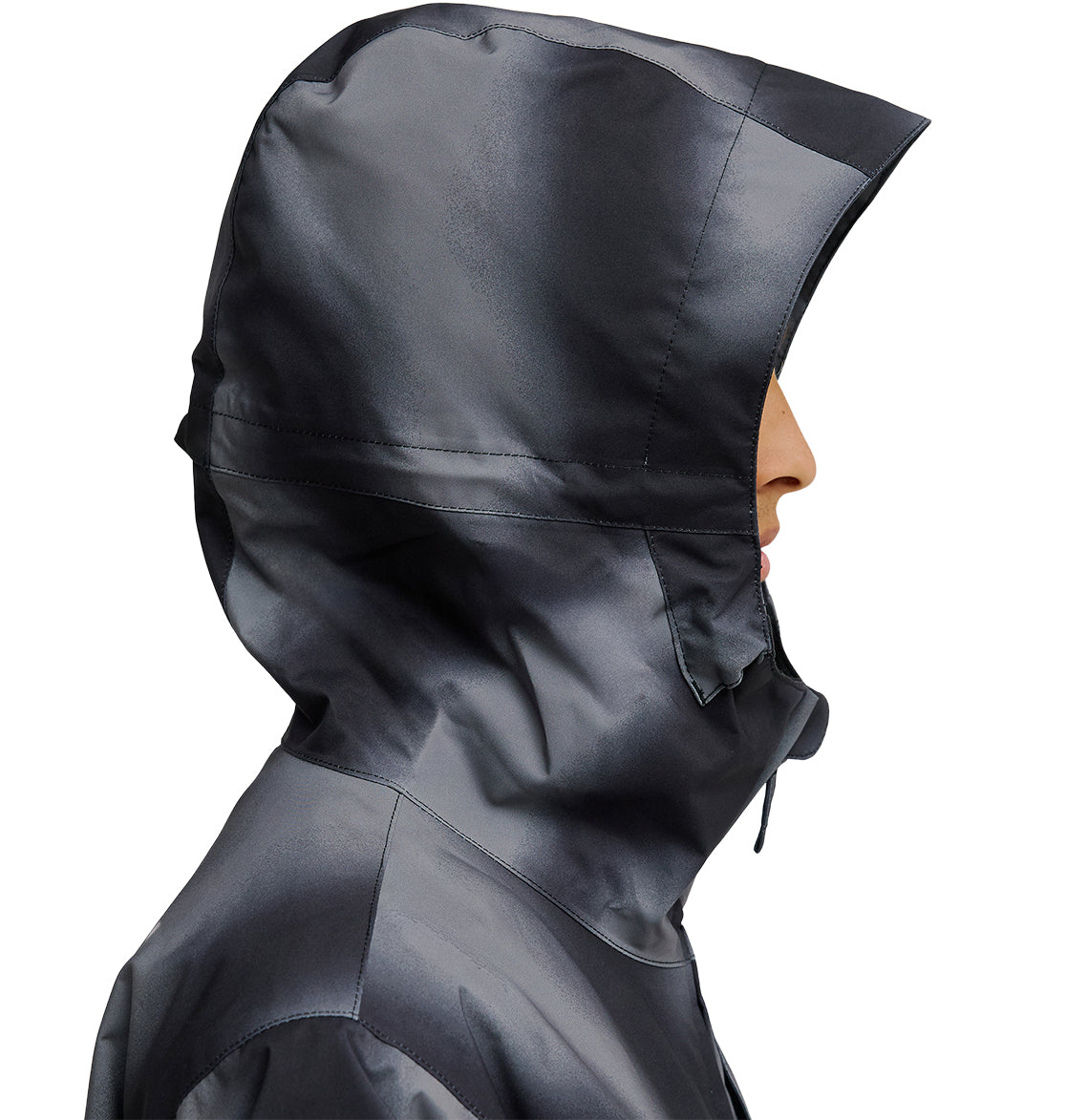 A person in profile view wears the DC Shoes Basis Jacket 10K—a shiny, dark gray waterproof jacket with the hood up, covering most of their head and face. The background is plain white.
