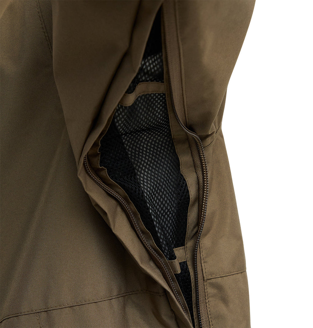 A close-up of a brown DC Shoes Basis Jacket 10K sleeve with an open zipper reveals a black mesh lining inside. Set against a plain white background, the details of this insulated, breathable jacket stand out.