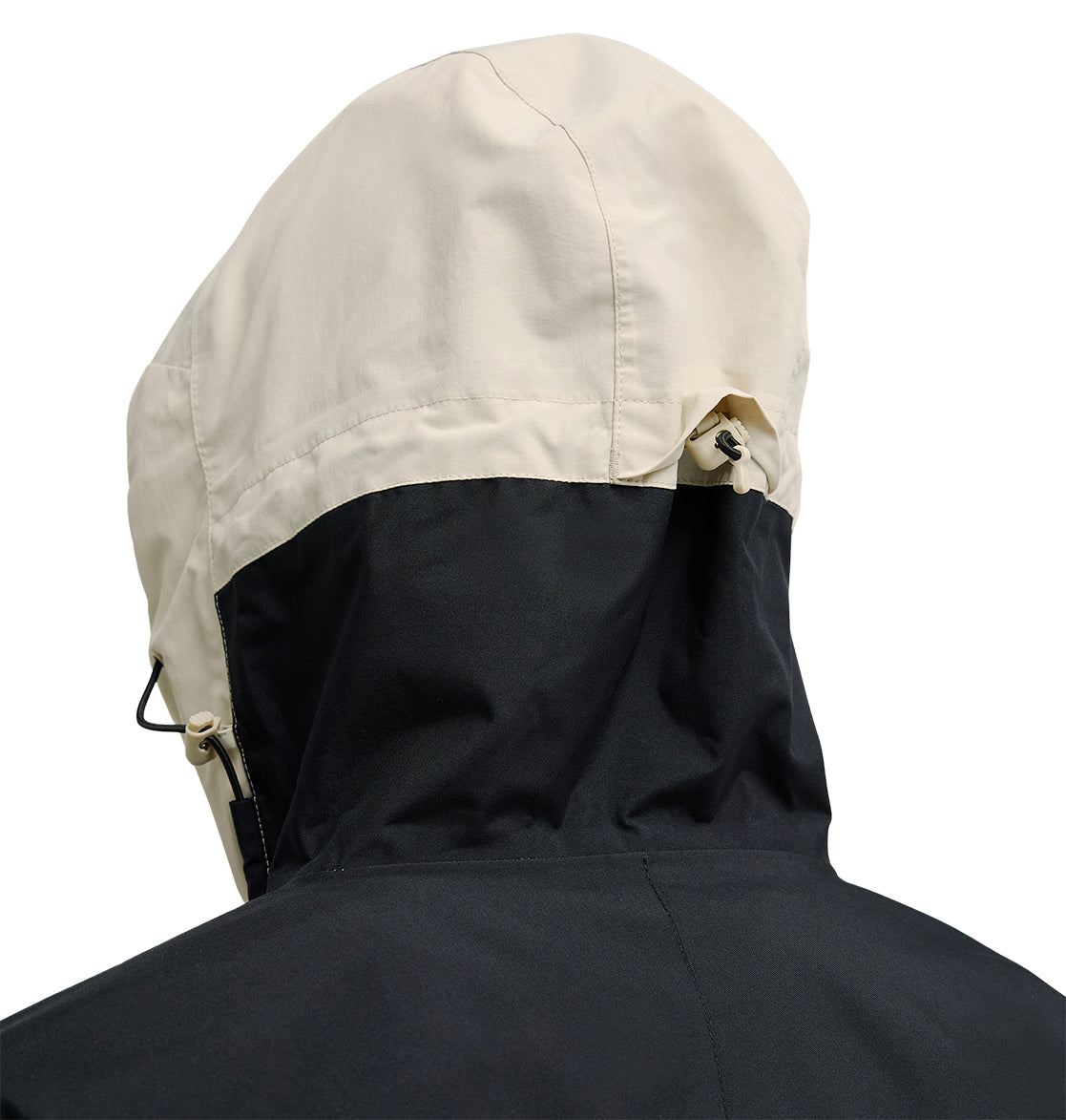 A close-up of the back of the DC Shoes Mountain Lab Anorak 10K jacket, featuring a black lower half and a beige hood with adjustable drawstrings for enhanced breathable protection.