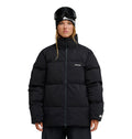 A person stands facing forward, wearing the DC Shoes Trackstar Puffer 10K jacket in black, which features breathable, waterproof protection. They have black ski goggles resting on their forehead and a black beanie. The jacket displays a small white DC Shoes logo on the left chest and left sleeve. The background is plain white.