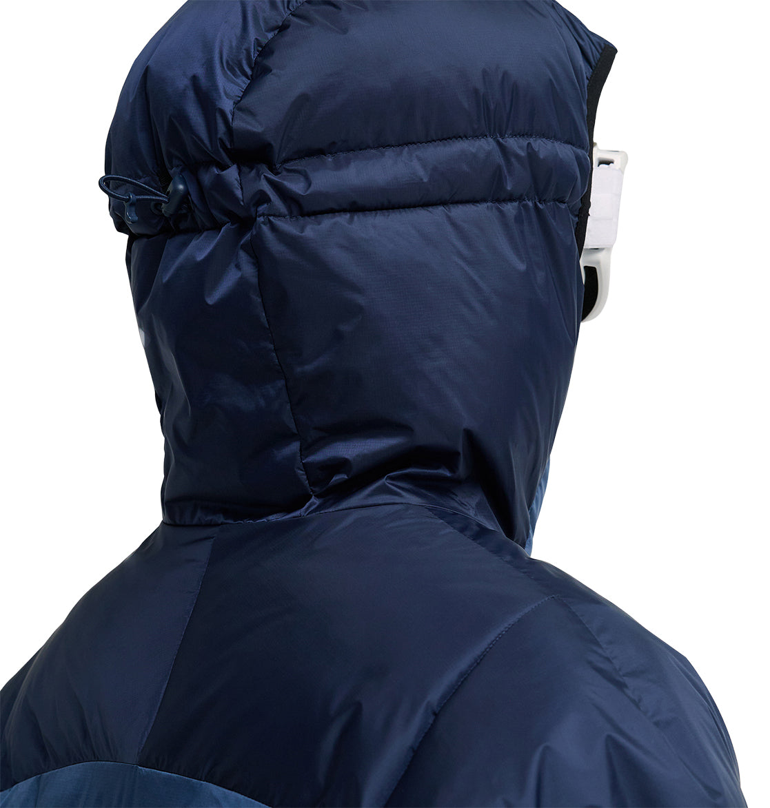 A person is seen from behind wearing the DC Shoes Powder Puffer 10K jacket in dark blue, with the hood pulled up to cover their head and white goggles obscuring most of their face. Designed by DC Shoes for exceptional insulation and snow performance, the Powder Puffer 10K is an ideal choice for cold-weather conditions.
