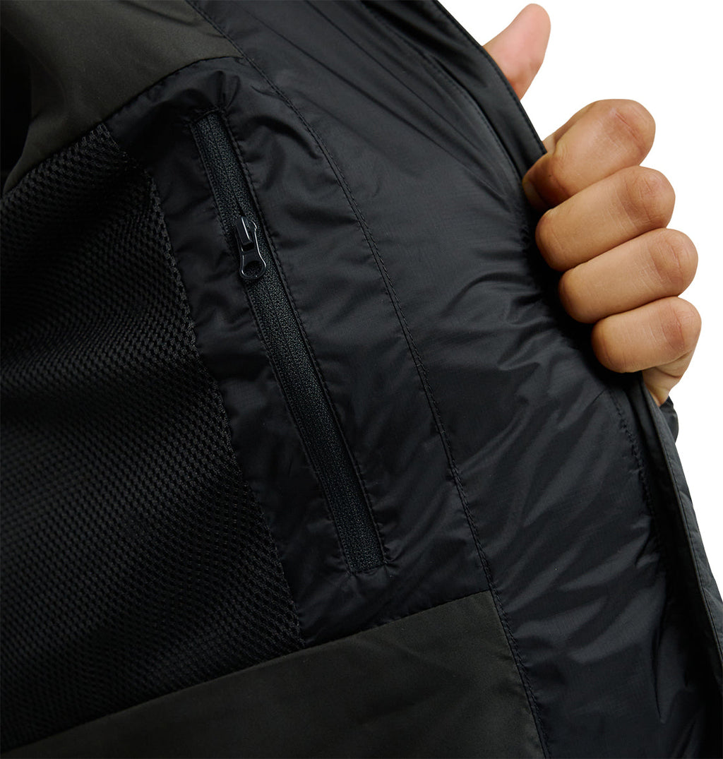 A hand holds open the DC Shoes Powder Puffer 10K jacket, revealing its inner zippered pocket and breathable mesh lining engineered for superior snow performance.