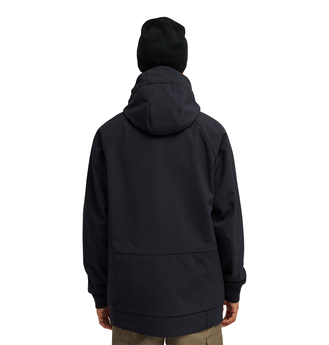 A person is shown from the back wearing a black DC Shoes Spectrum Softshell Jacket with the hood up and a black beanie, paired with khaki pants. The background is plain white.