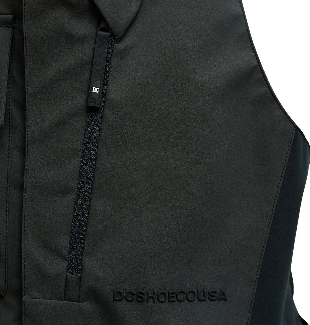 Close-up of the DC Shoes Storm Division 3L Bib 30K in black, featuring a zippered pocket and raised DCSHOECOUSA text on the fabric, designed for exceptional snow performance and breathable protection.