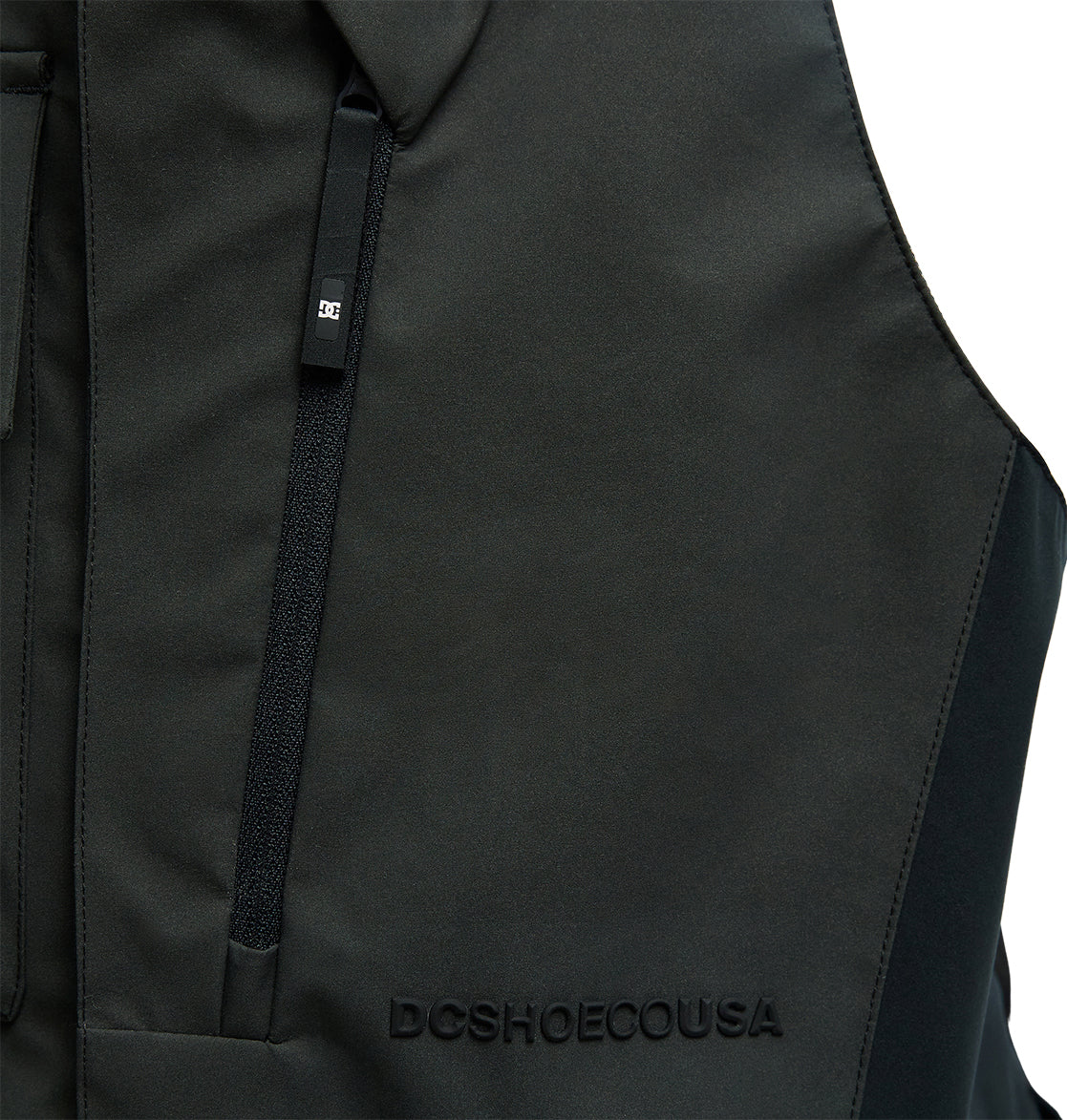 Close-up of the DC Shoes Storm Division 3L Bib 30K in black, featuring a zippered pocket and raised DCSHOECOUSA text on the fabric, designed for exceptional snow performance and breathable protection.