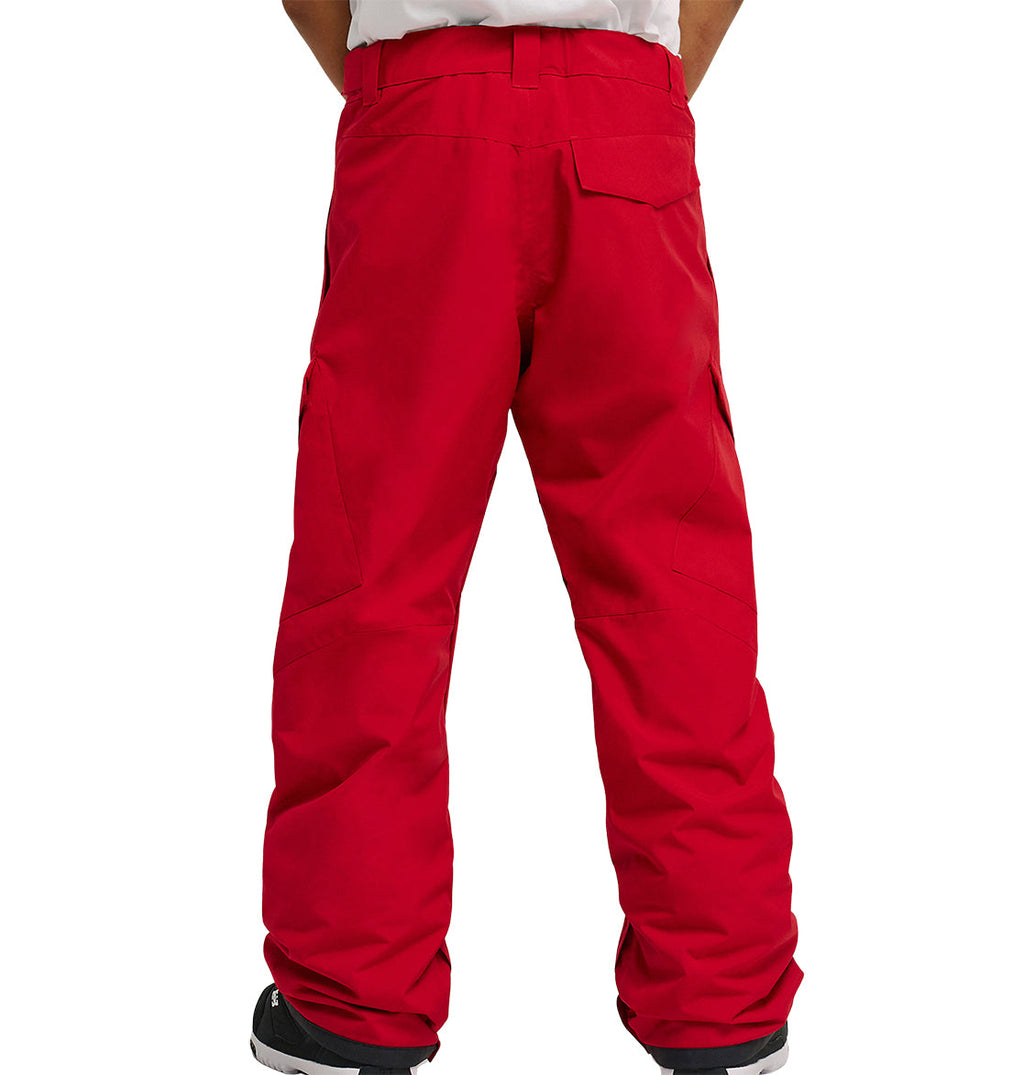 A person stands with their back to the camera, wearing DC Shoes Banshee Pants in bright red, featuring visible pockets and stitching details, paired with black shoes with white soles.
