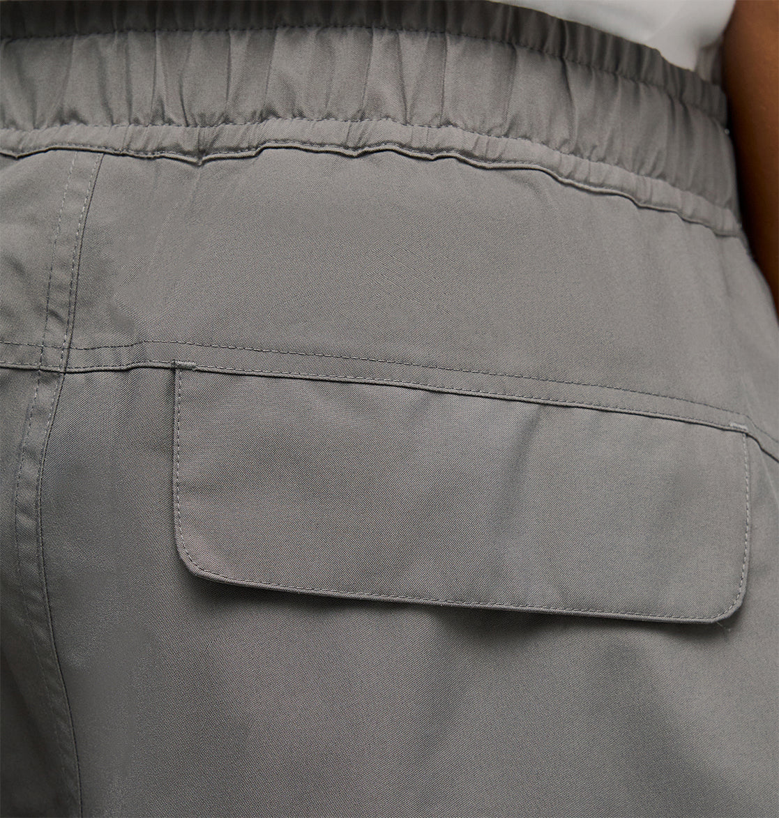 Close-up of the back pocket of the DC Shoes Smoke Pants 10K in gray, featuring an elastic waistband and flap closure for breathable protection and optimal comfort.