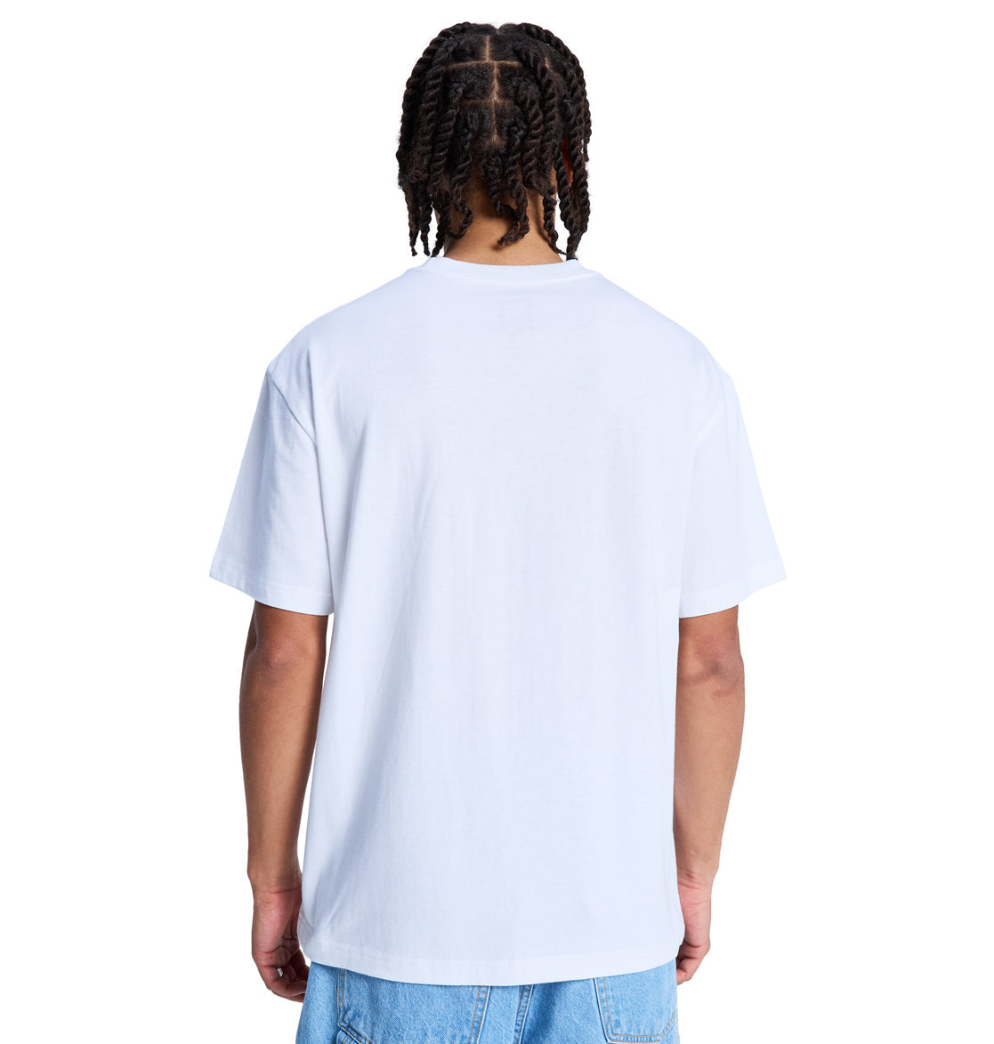 A person with braided hair, wearing the Reebok DC Star Filled Hss t-shirt and light blue jeans, stands with their back to the camera against a white background.
