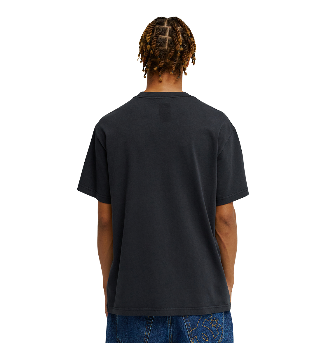 A person with braided hair is seen from behind, wearing the Men's DC Speratic Tee by DC Shoes in black paired with blue jeans against a plain white background.
