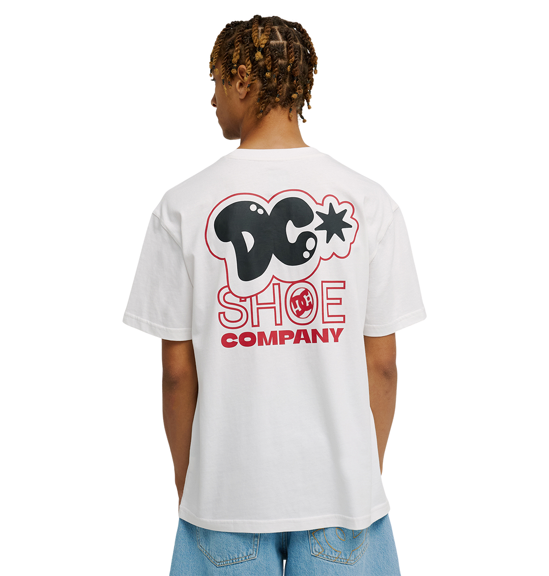 A person is seen from behind wearing the Men's DC Side Flame Tee by DC Shoes—a relaxed fit white T-shirt featuring a bold black and red DC Shoe Company logo on the back—paired with light blue jeans.