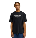 A person with short, braided hair wears the Men's DC Heritage Font Tee by DC Shoes in black, styled in a relaxed fit with blue jeans, standing against a plain white background.